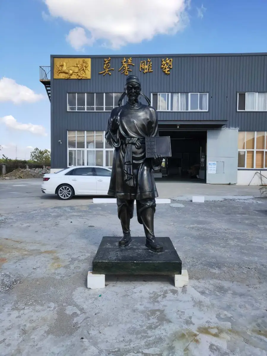 Bronze figure in traditional robes in the foundry yard