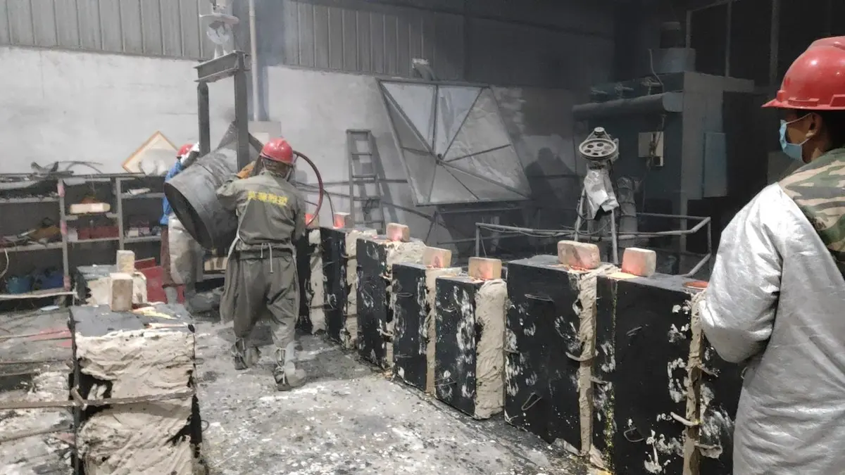 Workers pouring molten metal with a ladle in the casting shop