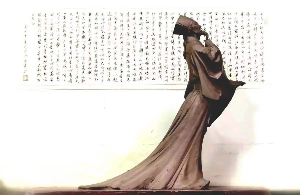 Classical Chinese lady bronze sculpture against calligraphy backdrop