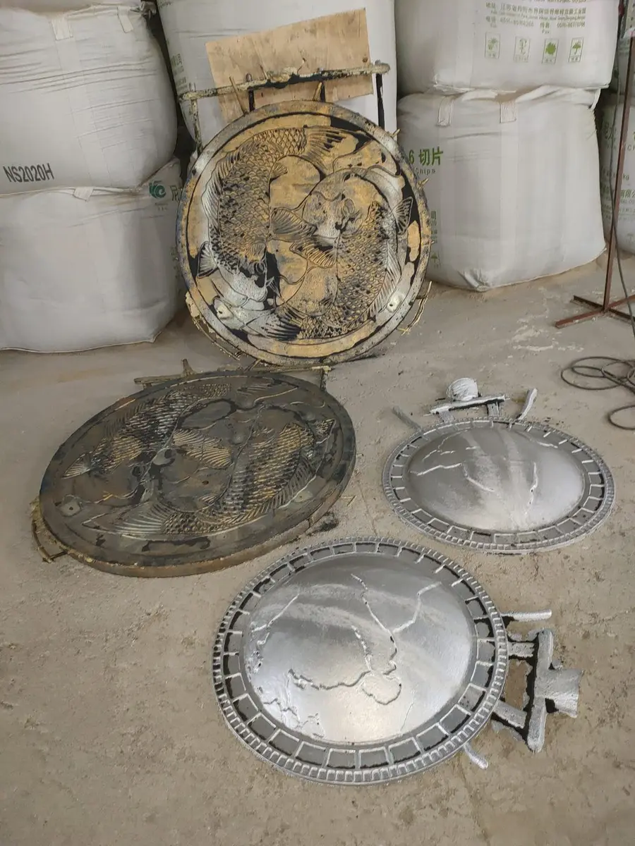 Circular metal castings with carved fish patterns at the workshop