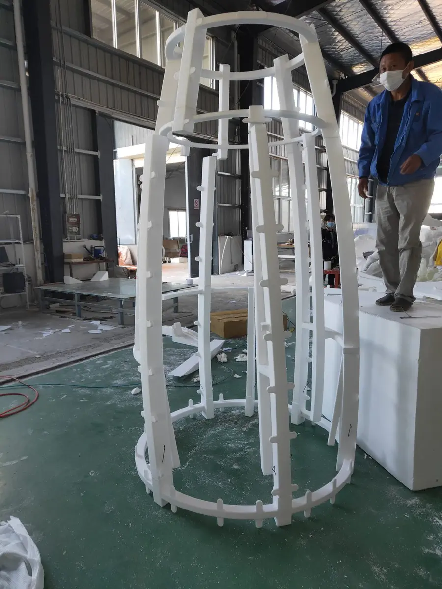 Large white foam structure being shaped in the workshop
