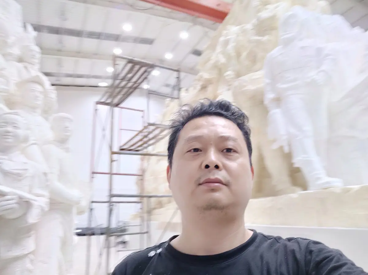 Craftsman working on a large foam sculpture in the workshop