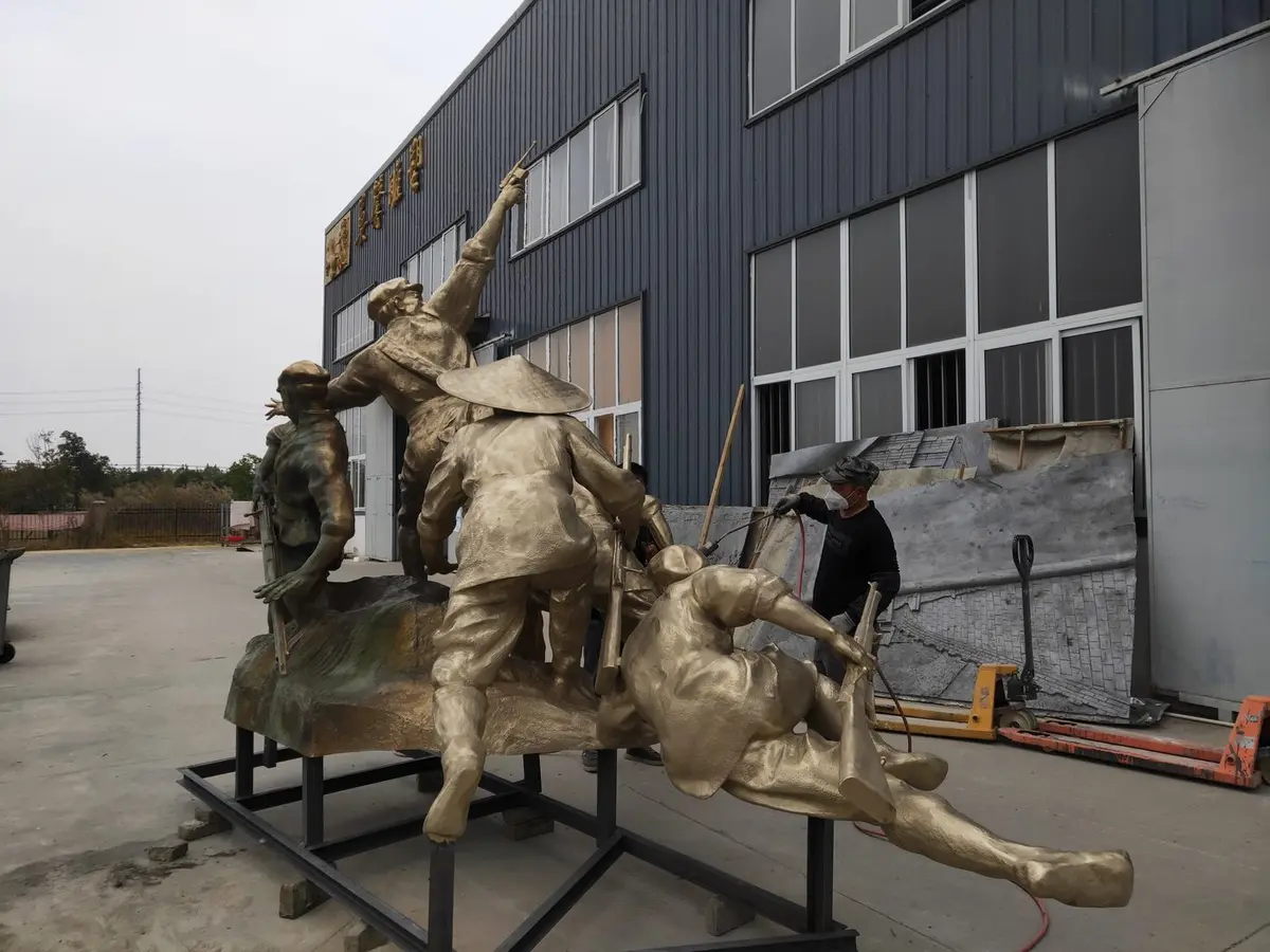 Craftsman finishing a monumental bronze group sculpture