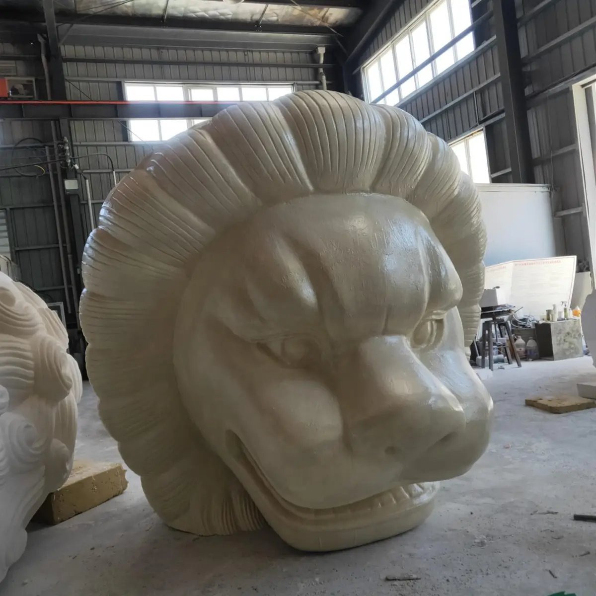 Large white lion head sculpture in progress with detailed mane