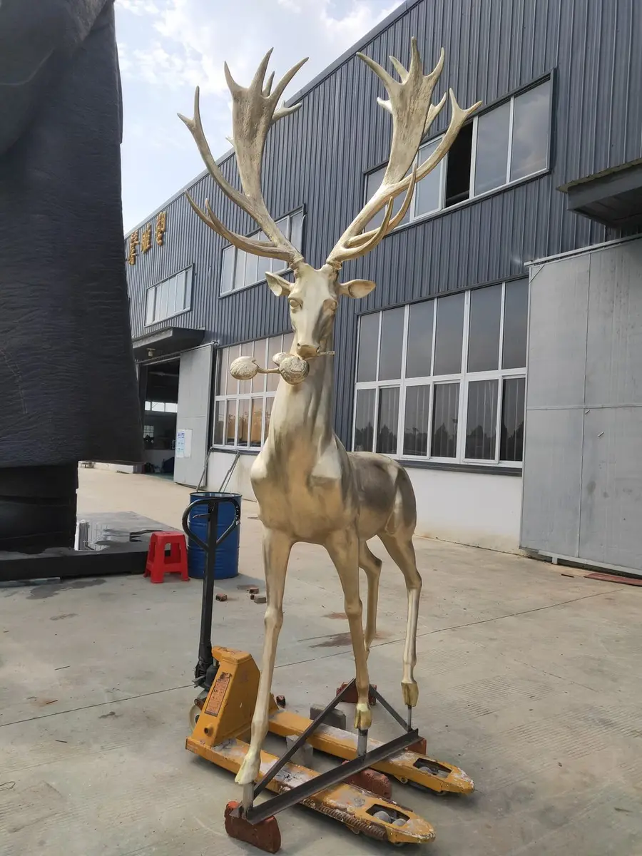 Golden moose sculpture prepared for transport on a hydraulic cart