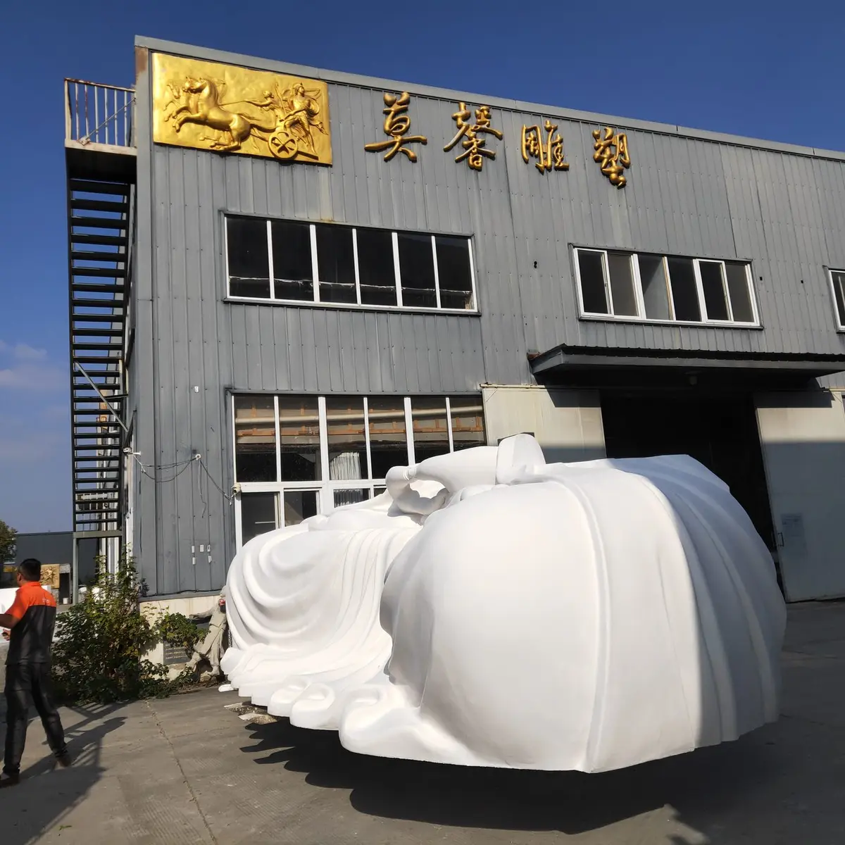 Moxin foundry facade with a large white foam sculpture outside