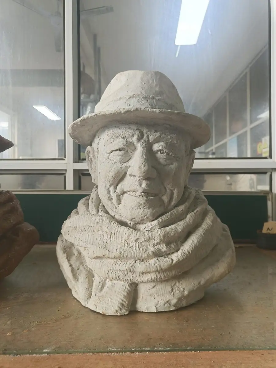 Plaster portrait bust of an old man with a wide hat and scarf