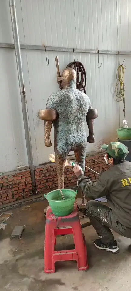 Craftsman applying patina with a torch