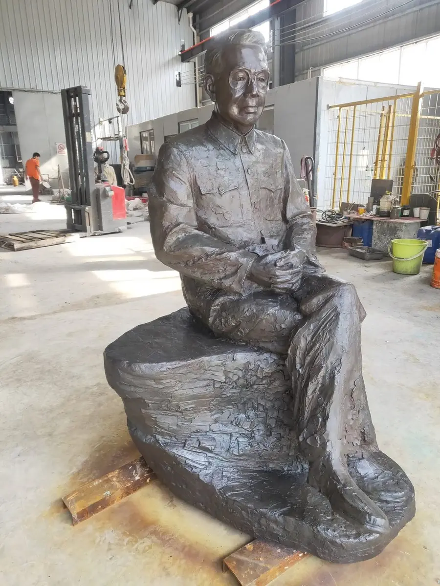 Bronze seated figure of a man in a Zhongshan suit on a rock base