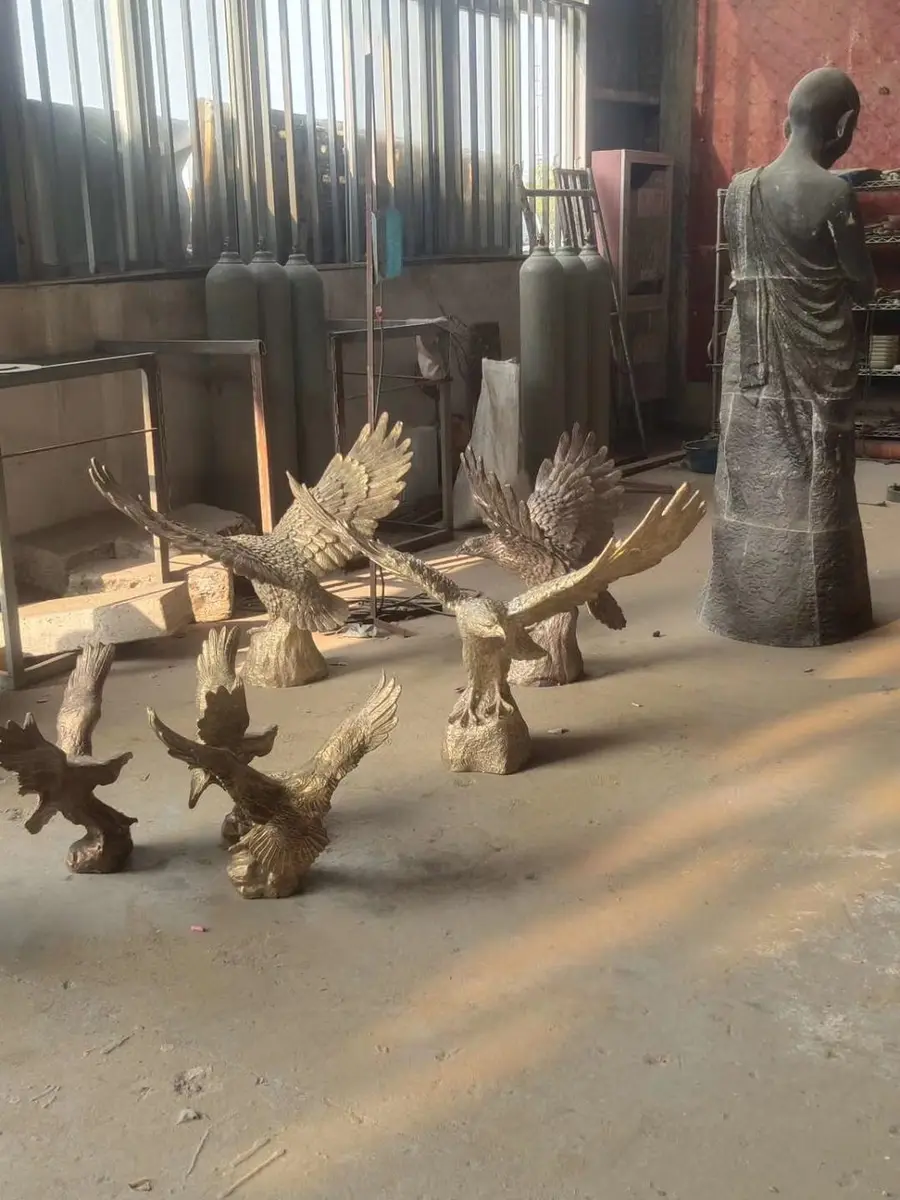 Stone sculpture of a bird and figures in the workshop