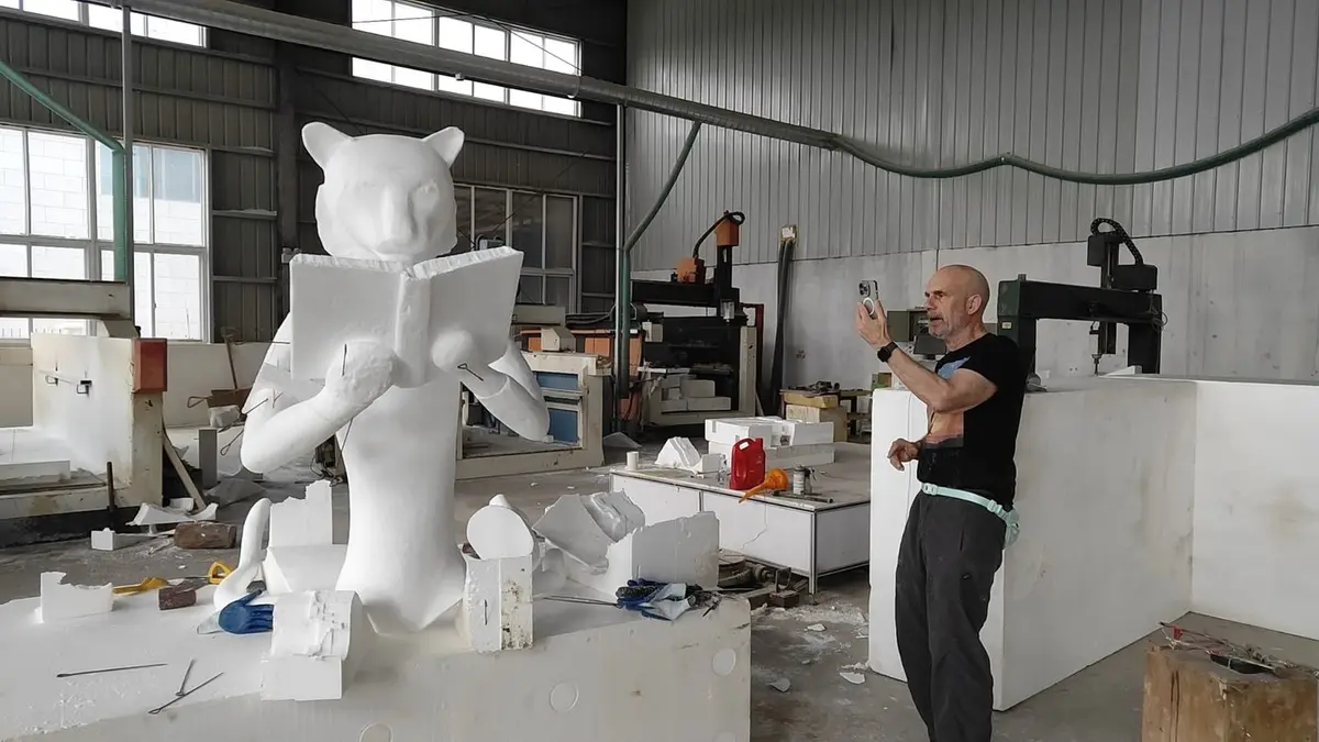 Tiger-head figure foam model reading a book with a client inspecting